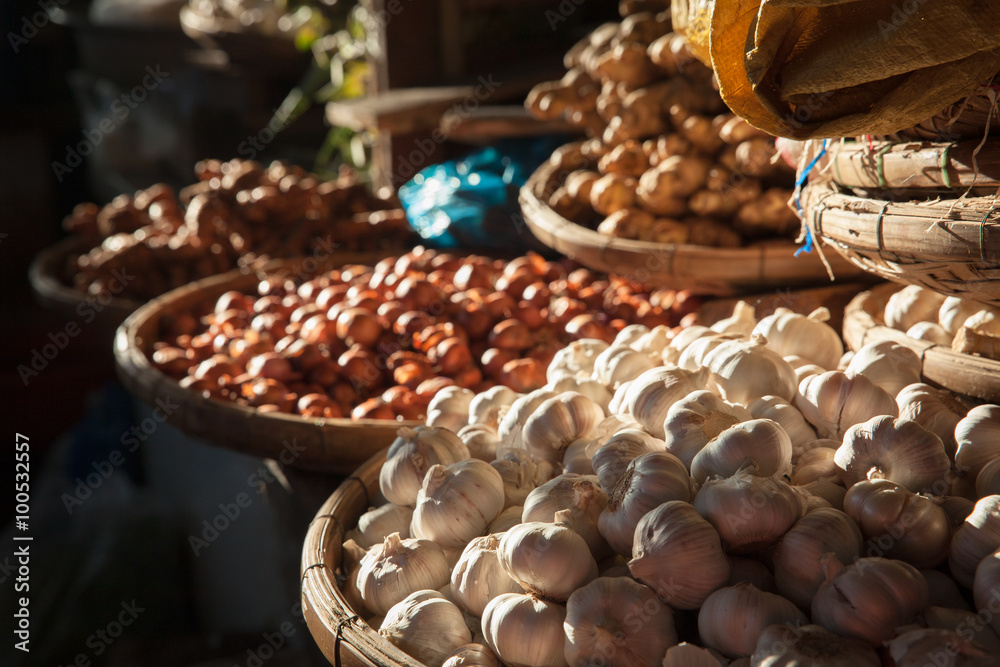 Baskets with garlic and onions under morning light at the street market, Nha Trang, Vietnam.