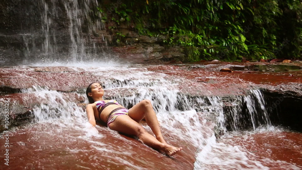 sexy girl with bikini lying down in waterfall river sexy girl with bikini lying down in waterfall river