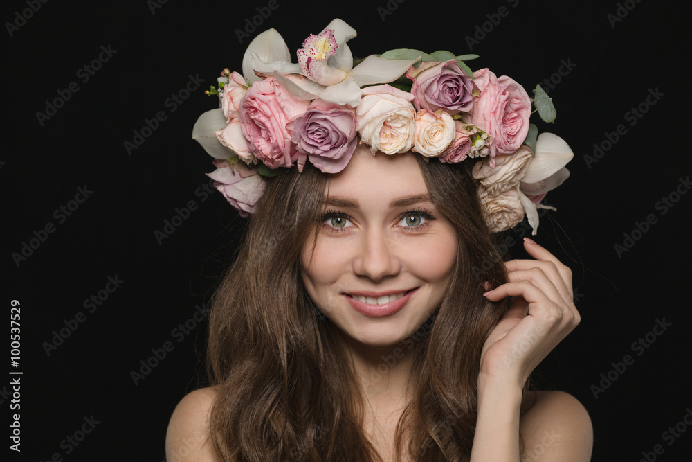 Naklejka premium Woman with wreath from flowers on head looking at camera