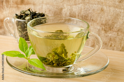 The cup of hot green tea (Healthy drink) on wooden background