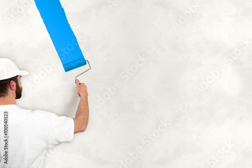 painter painting wall with blue color photo