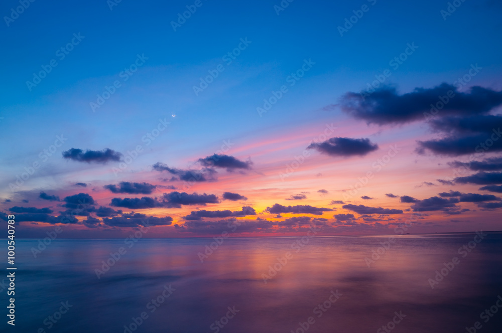 Sunset sky and sea at dusk with crescent moon