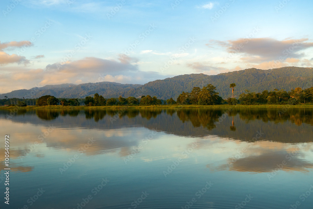 Reflection by the lake with beautiful clouds formation. Nature landscape.
