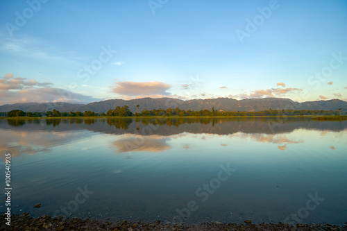 Reflection by the lake with beautiful clouds formation. Nature landscape.