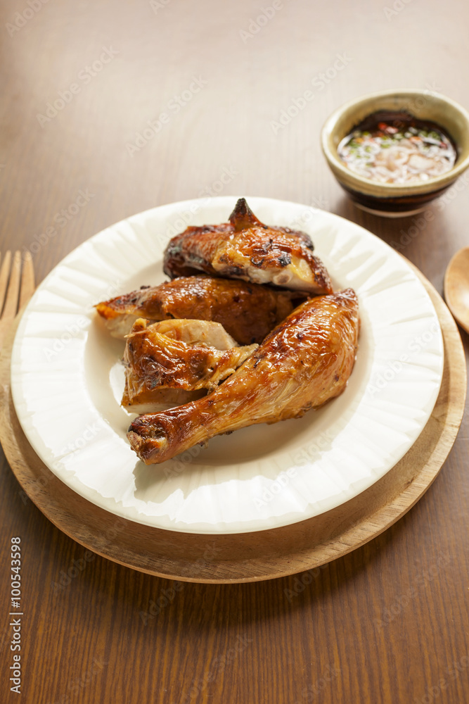 Grill chicken in Thai style on wooden tray with spicy thai sauce Grill chicken in Thai style on wooden tray with spicy thai sauce