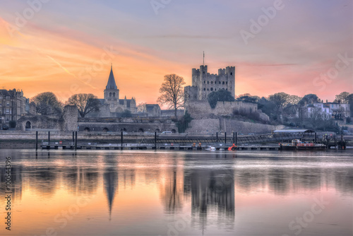 Rochester, United Kingdom - March 12, 2015: Early morning picture with medieval structures, sunrise and reflection on river.