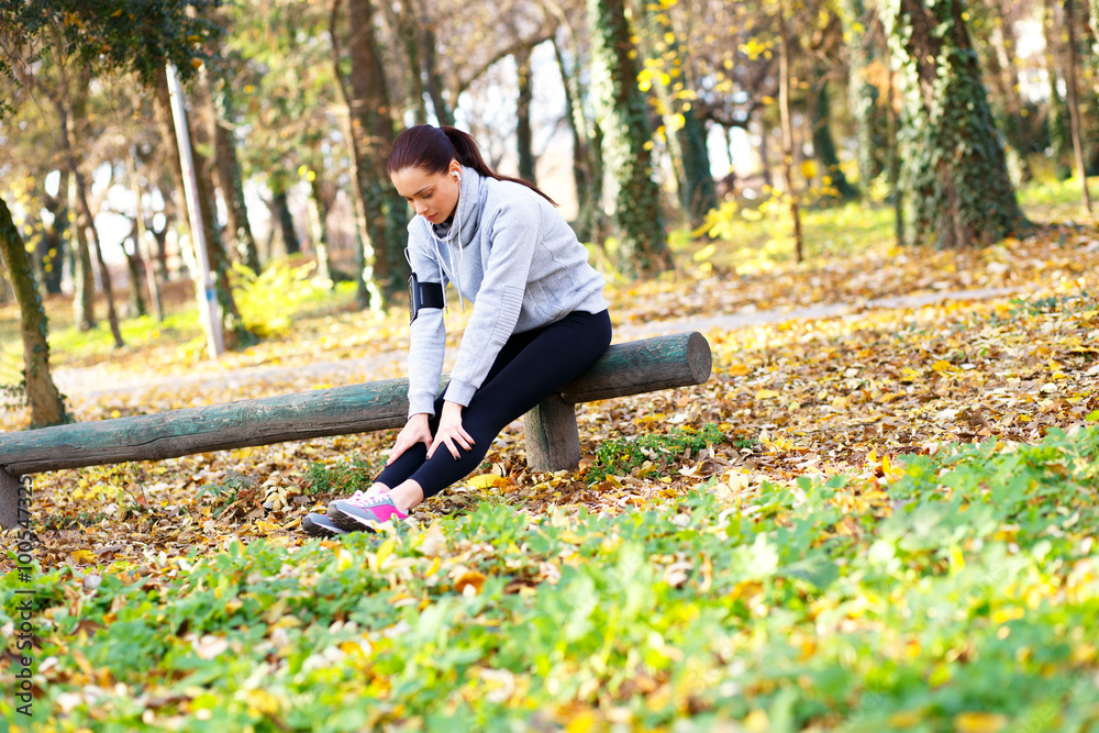 Young woman resting after jogging in park Young woman resting after jogging in park