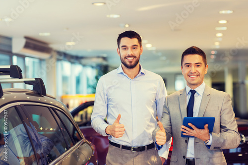 happy man showing thumbs up in auto show or salon