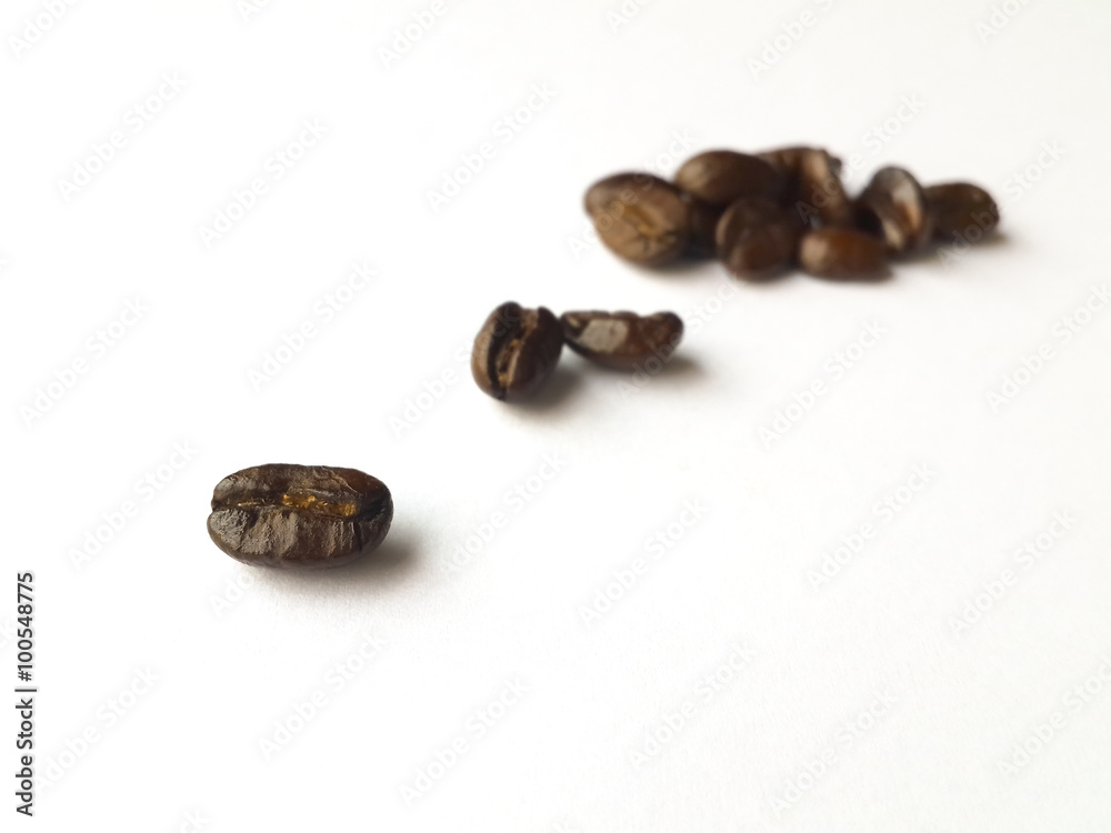 Obraz premium Coffee beans on white background, selected focus