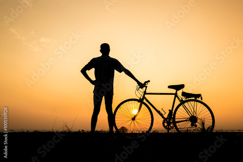 silhouette of man and bicycle on sunset sky