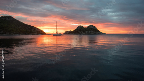 Panoramic view of the sea bay early in the morning at sunrise with the mountains and parking yacht in the background
