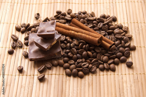Chocolate, coffee beans and cinnamon on a background