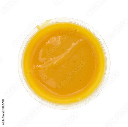 Container of honey mustard dressing on a white background