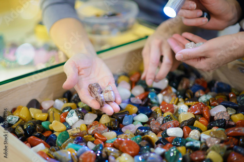 Colored stones. Round semi-precious minerals. Polished minerals. Beautiful natural stones. People with hand sorted stones. Geology and geography. Semi-precious stones. A scattering of stones.