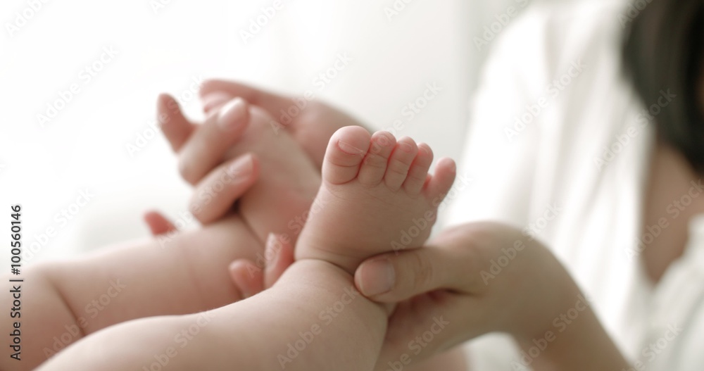 parent hands touch the baby's legs, in the background light, slow motion parent hands touch the baby's legs, in the background light, slow motion