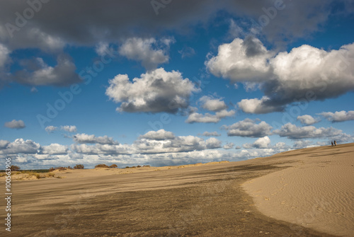 Two men are walking through the desert