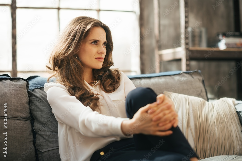 Portrait of young weatlhy woman sitting on couch and dreaming Portrait of young weatlhy woman sitting on couch and dreaming