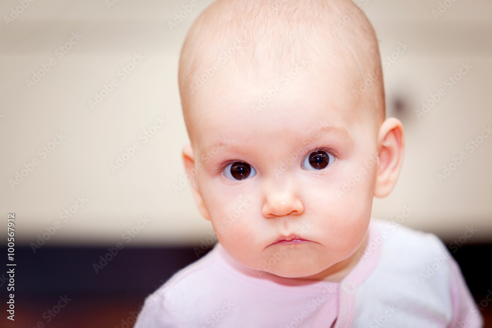 Close-up of a small child who cries but does not scream. A tear rolling down his cheek. Blurred background. Photo girl.
