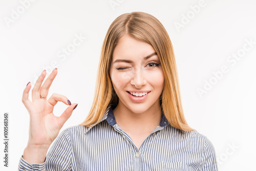Cheerful young businesswoman gesturing "OK", close up photo