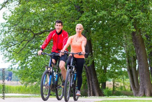 Woman and man on mountain bike in the woods