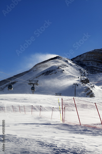 Gondola lift on ski resort at windy sun day photo