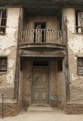 eski ve harabe olmuş bina duvar yüzeyi kapı ve camlar, Retro ufak kapı sıvası dökülmüş duvar  kahverengi kerpiç konak arka plan duvar dokusu harabe yapı balkon ve mimari