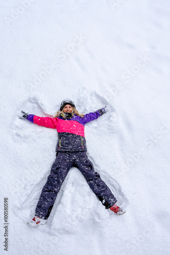 Girl laying on snow and making angel