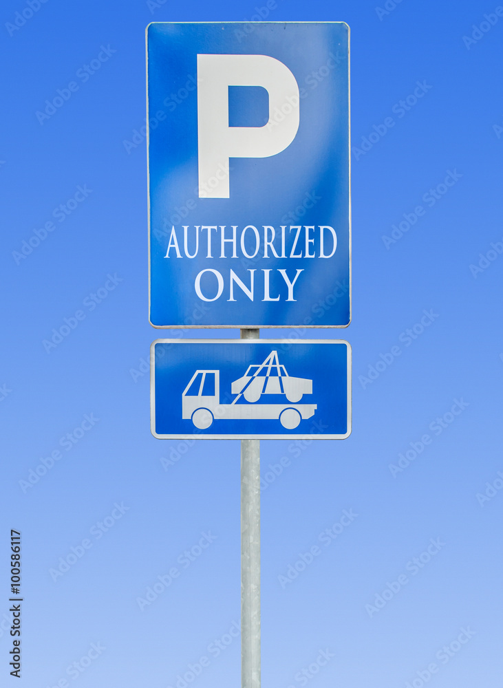 Road parking sign isolated against a blue sky with authorized only and tow truck sign Road parking sign isolated against a blue sky with authorized only and tow truck sign