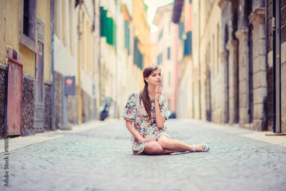 Beautiful girl sitting on street