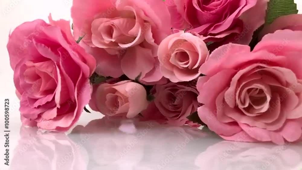 Little Valentine heart raining down on bouquet of pink roses on white background Little Valentine heart raining down on bouquet of pink roses on white background
