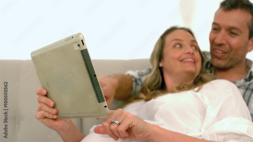 Happy future parents using tablet Happy future parents using tablet