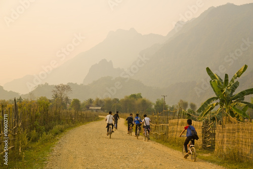 Children cycling, Sunset at limestone mountains of Vang Vieng, Laos