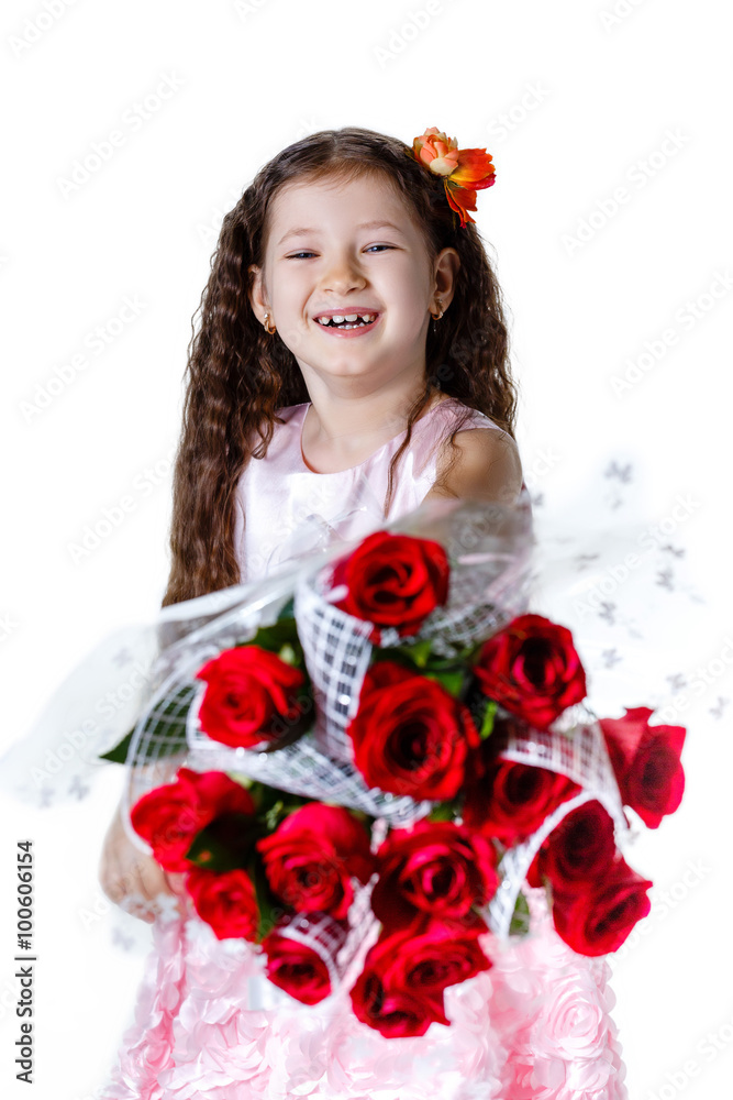 beautiful little girl in a pink dress with a bouquet of red roses