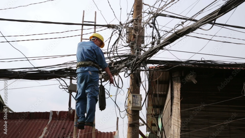 electrician fixing, repairing messy electric cables in hanoi slums, vietnam electrician fixing, repairing messy electric cables in hanoi slums, vietnam