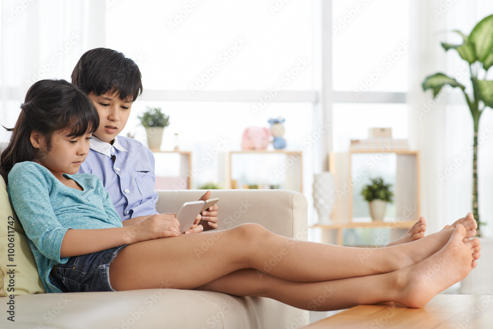 Siblings with smartphones