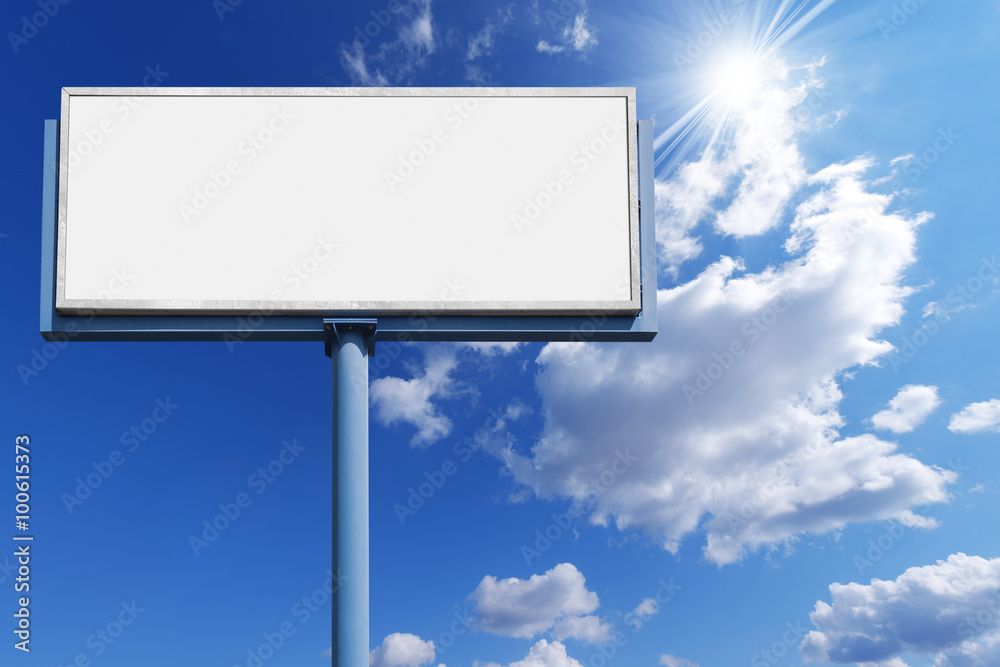 Blank Billboard Against a Blue Sky / Big empty billboard with blue pole on a blue sky with clouds and sun rays Blank Billboard Against a Blue Sky / Big empty billboard with blue pole on a blue sky with clouds and sun rays