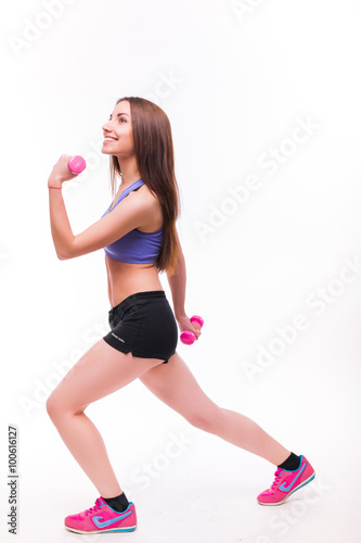 Active sportive athletic woman with dumbbells pumping up muscles biceps concept fitness sport training lifestyle