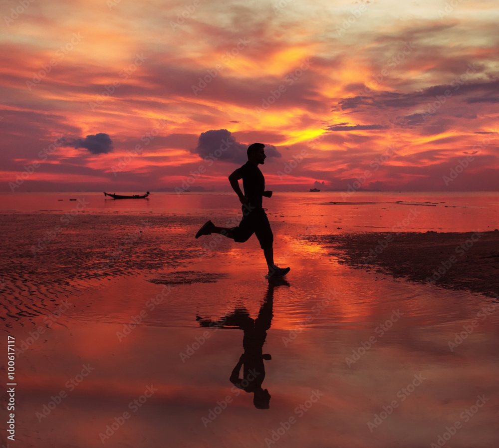  jogger on sunrise along the sand beach with mirror on the water