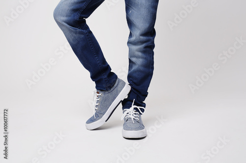 Young boy in jeans and sneakers, low section