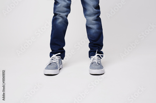 Young boy in jeans and sneakers, studio shot