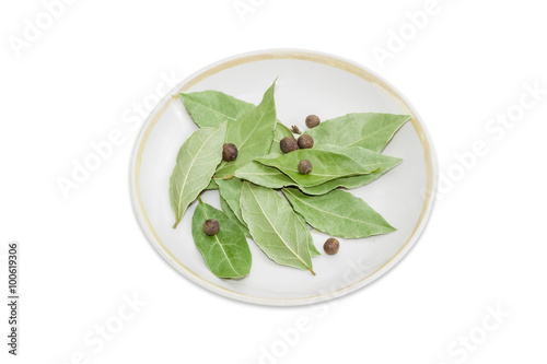 Dried bay leaves and allspice on a saucer