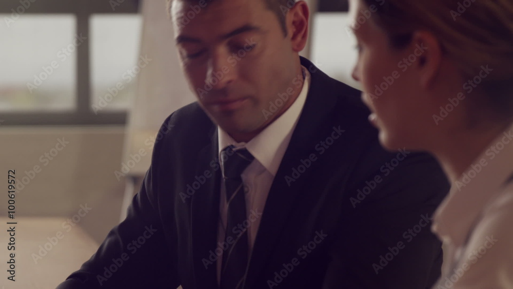 Serious business people working together while looking tablet Serious business people working together while looking tablet