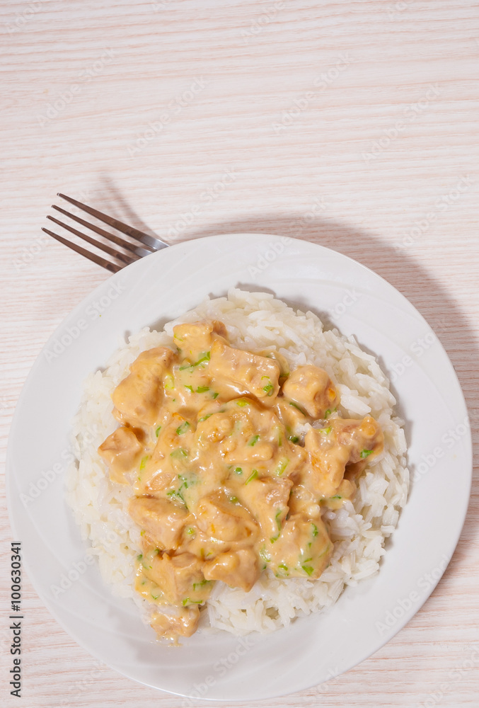 Pieces of chicken fillet and cheese sauce with rice