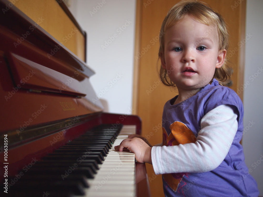 Fototapeta Little girl practising the piano
