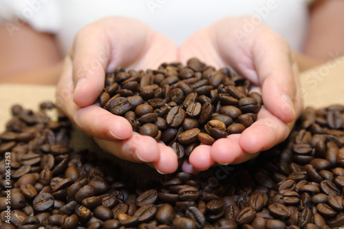 background of roasted coffee beans pouring out of cupped hands
