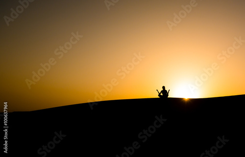 silhouette of a man sitting in a pose against the sky