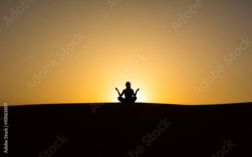 silhouette of a man sitting in a pose against the sky