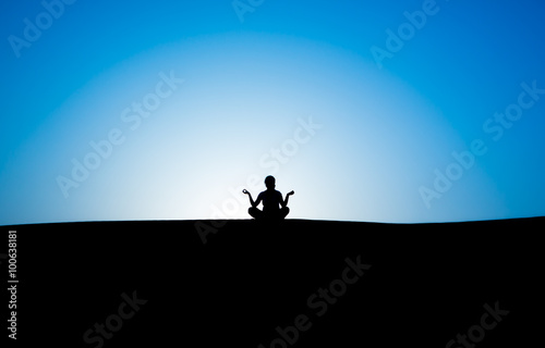 silhouette of a man sitting in a pose against the sky