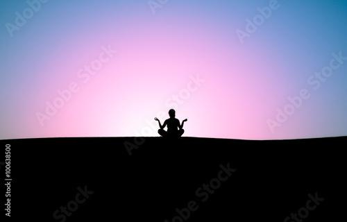 silhouette of a man sitting in a pose against the sky