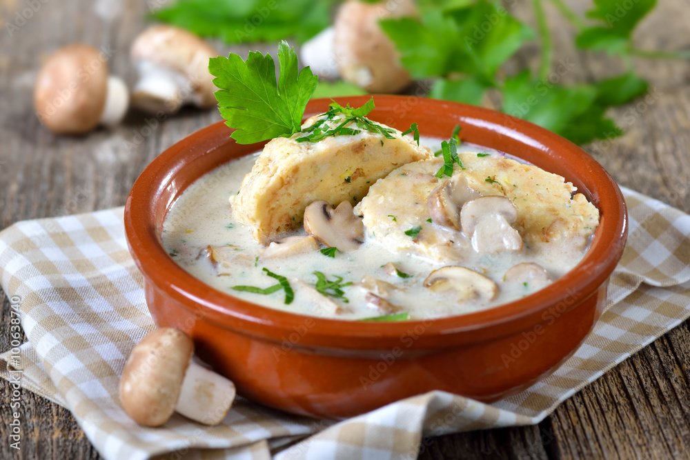 Deftige Rahmchampignons mit Semmelknödel in der Keramikschale serviert ...